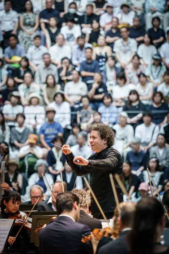 開演前から熱気に包まれたステージに、指揮者のグスターボ・ドゥダメルが登場 (c)Stephan Rabold