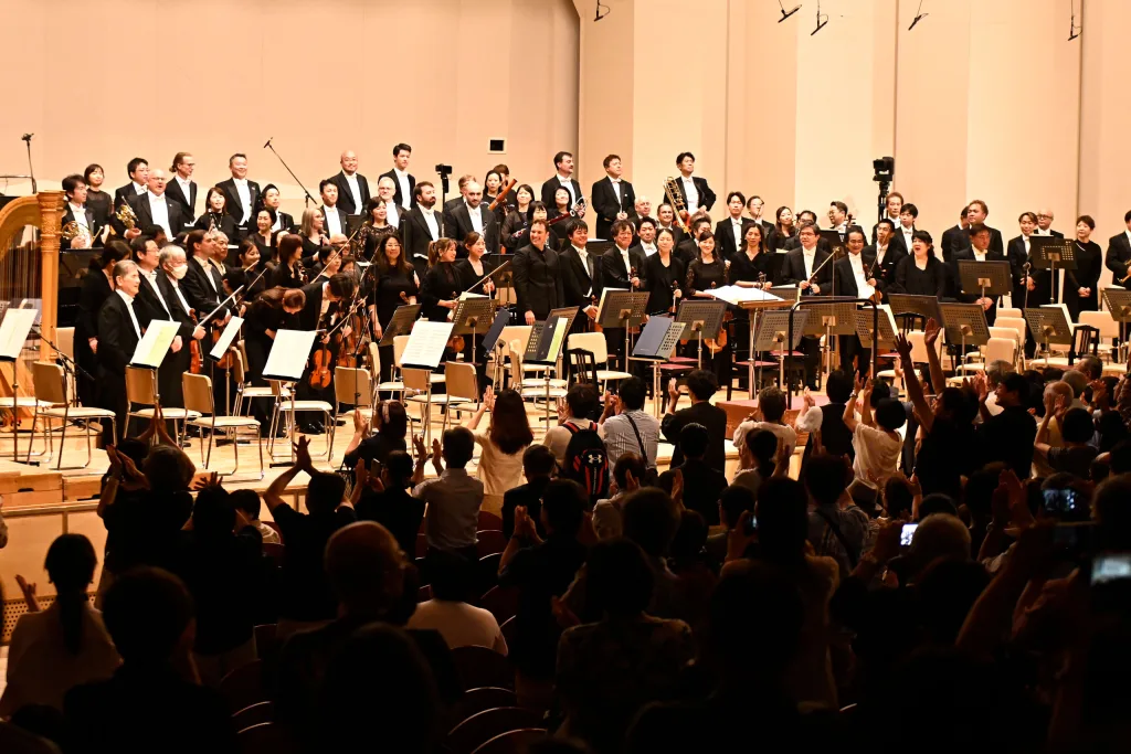終演後、指揮者とオケ・メンバー全員がステージに再登場して歓呼に応えた (c)山田毅/2025OMF