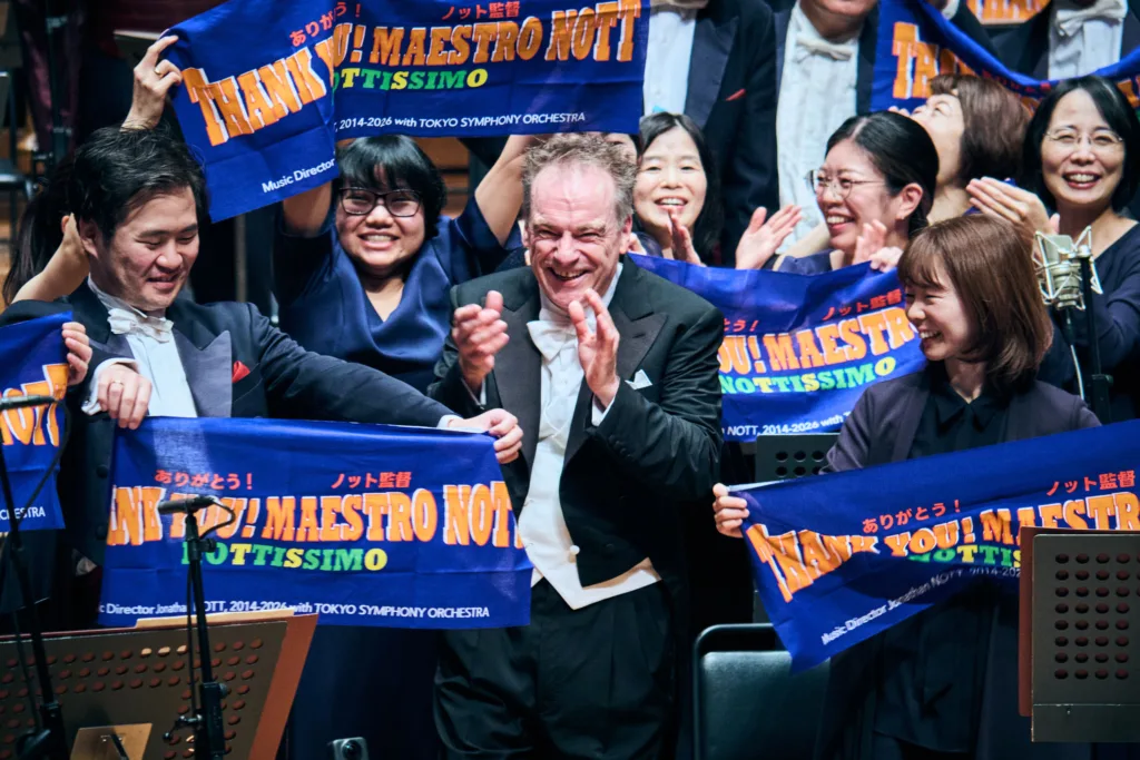終演後、「ありがとう！ノット監督」などと書かれた布を持ったオケ・メンバーがステージに再登場し音楽監督として黄金時代を築いたジョナサン・ノットに謝意を表した　©平舘平／ミューザ川崎シンフォニーホール