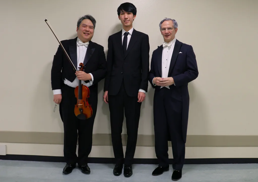 Ｎ響定期に初登場したショパン国際ピアノコンクールの優勝者エリック・ルー（中央）と指揮のファビオ・ルイージ（右）、コンサートマスター川崎洋介　写真提供＝ＮＨＫ交響楽団