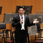 プレ・トークでフランスのオーケストラがブラームスの交響曲を演奏することの意義を語るユージン・ツィガーン