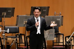 プレ・トークでフランスのオーケストラがブラームスの交響曲を演奏することの意義を語るユージン・ツィガーン